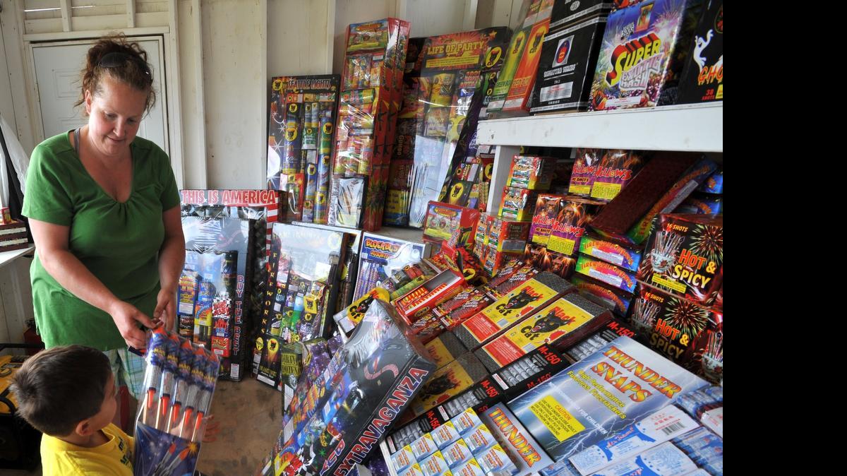 
Meo Carrillo, 4, helps his mom, Susan Julius set up the Pyro-Maniac fireworks stand on Haxton Way on the Lummi Reservation on, June 25, 2010. 

