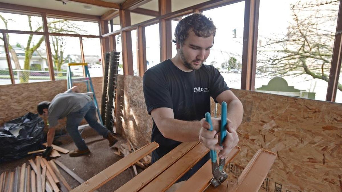 RE Store workers Zack Zuniga, left, and Jake Bollinger strip the inside of the old Community Connections building on Forest Street in Bellingham on Tuesday, Feb. 16, 2016. The building is being removed and the material recycled to make way for additional parking for the Community Food Co-op store.
