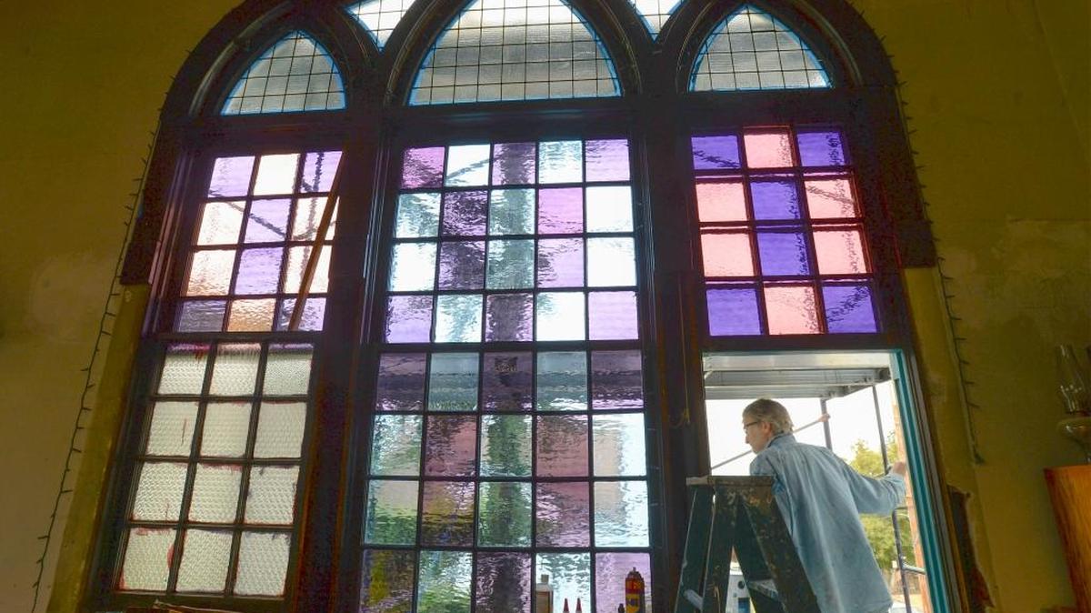 Richard Sands steps out a window onto a scaffold while painting his home, a former church built in 1910 in the York Neighborhood, Thursday, Sept. 1, 2016. The building once housed Lutheran and then Unitarian congregations.