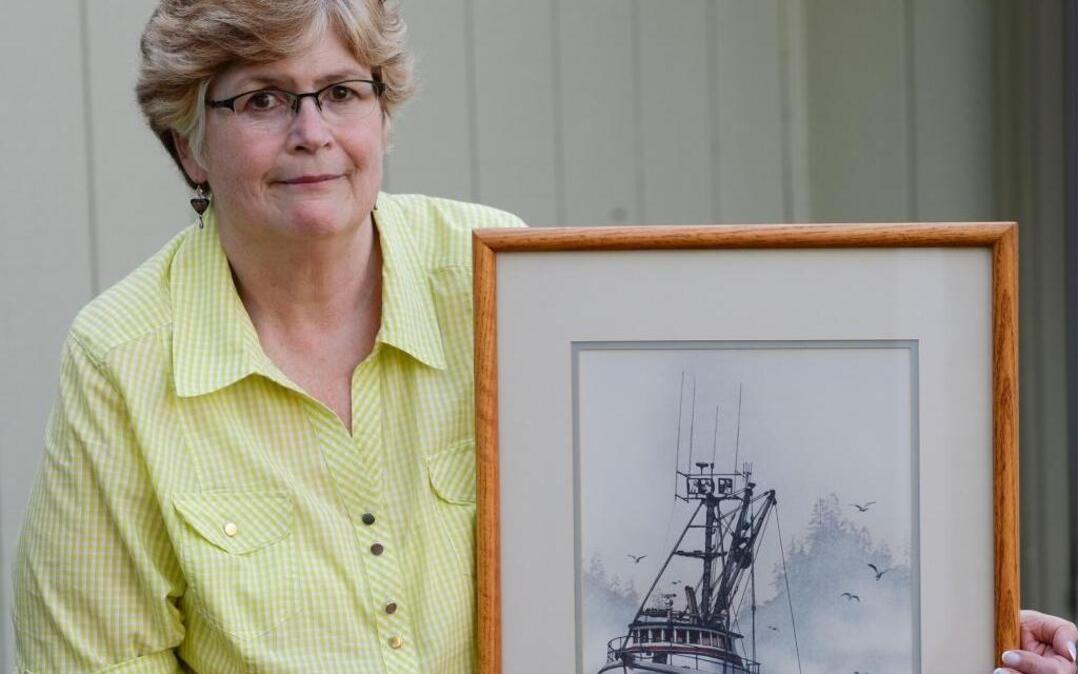 Laurie Hart poses with a painting of her brother Mark Coulthurst’s fishing vessel Investor by local artist James Williamson at her Blaine home Wednesday, April 20, 2016. An exhibit called “Lost At Sea: Remembering the Victims of the F/V Investor Murders,” is at 3:30 p.m. Sunday, May 1, at the Blaine High School cafeteria to remember Coulthurst, his family, and crew members who were murdered on the Investor in 1982 in Alaska.