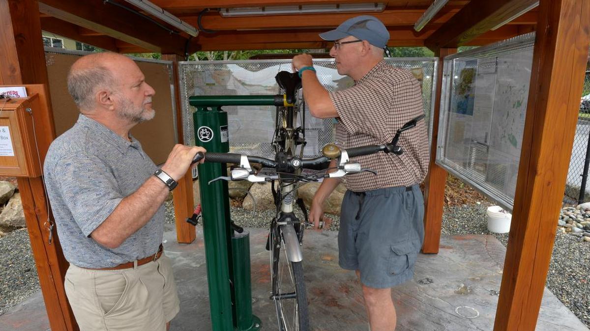 
A-1 Builders president Rick Dubrow, left, and employee Patrick Martin mount a bike July 24 at the new bike-maintenance station the company built outside its offices at 3310 Northwest Ave. in Bellingham. The self-service station offers free use of tools, a bike pump, how-to repair books, maps and other information.
