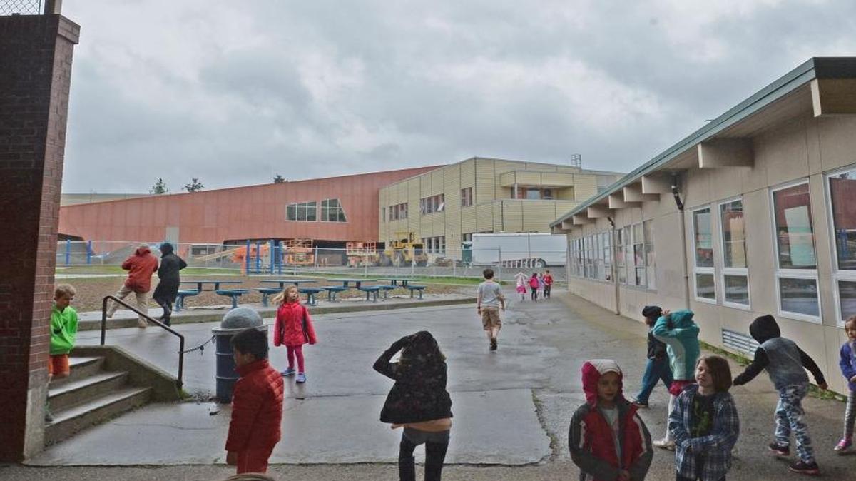 Children unwind during recess at Happy Valley Elementary School on Wednesday, March 23, 2016, in Bellingham. Their 60-year-old school will be demolished this summer to make way for the $19 million replacement building in the background, which will open Aug. 24.