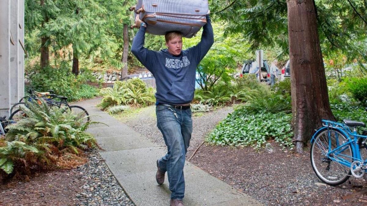 Western Washington University freshman Jake Branscum-Higuera carries his belongings into the Fairhaven Complex on Saturday, Sept. 17, in Bellingham.