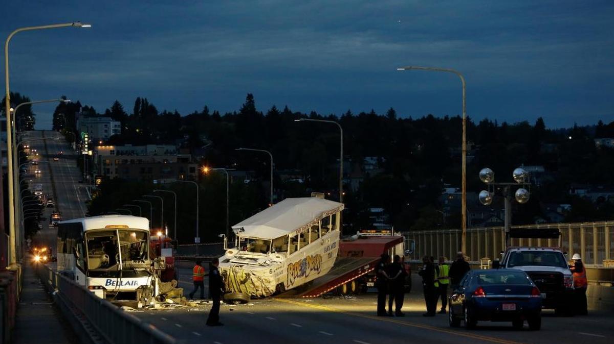 
A “Ride the Ducks” tourist vehicle, center, is loaded onto a flatbed tow truck in the late evening Thursday, Sept. 24, 2015, after it was involved in a fatal crash with the charter passenger bus, left, and other vehicles in Seattle.
