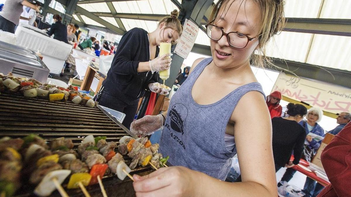Rika Wong, right, and Emma Fein prepare lemongrass pork skewers for The Rickshaw during the Bite of Bellingham on Sept. 20, 2015, at Depot Market Square in Bellingham. The annual event has ended after 10 years.