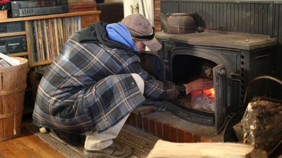 In this 2014 photo, Mack Underwood adds firewood to the stove in his Raleigh, N.C. home. The Northwest Clean Air Agency says Whatcom County residents, especially those in the Columbia Valley, should avoid burning wood over the next few days because of declining air quality. An air stagnation advisory is in effect through noon Monday, Nov. 30, 2015.