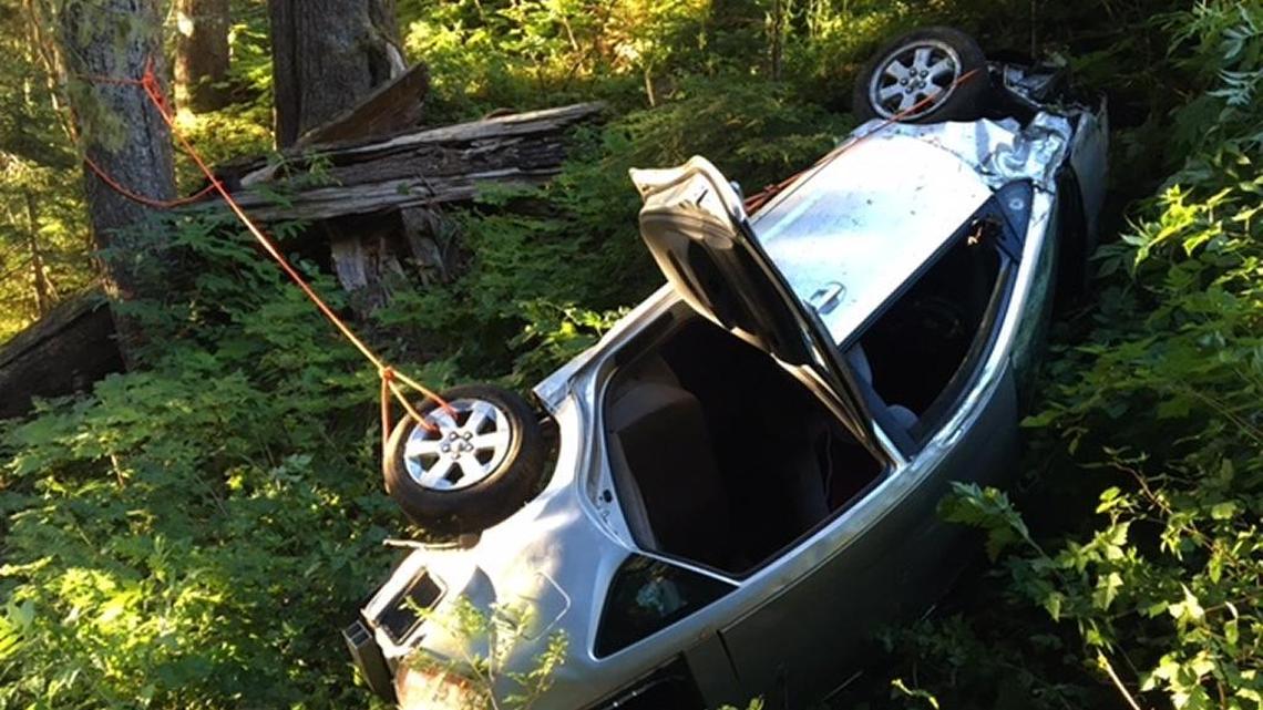 Firefighters rigged a rope system to rescue a Bellingham man who suffered serious injuries when his car hurtled 250 feet over a steep embankment near the end of the Mount Baker Highway in the predawn hours of Thursday, Aug. 11. The wrecked Toyota Prius is held with ropes to keep it from rolling farther downhill.