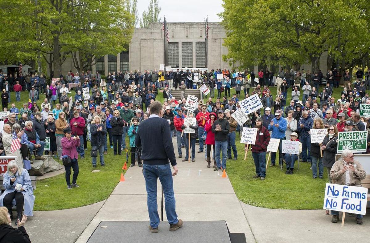 Jim McKinney, executive director of Common Threads Northwest, speaks before hundreds of people gathered for a "Wake Up Whatcom County" rally at the Bellingham Public Library lawn on Tuesday, May 16. The rally was held over concerns of Whatcom County Council decisions impacting farming, property values, and jobs.