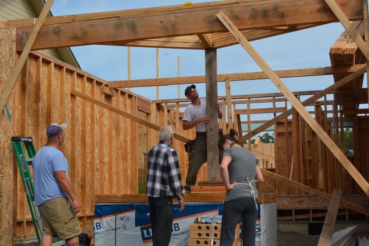 Nate Ashby, from left, Carl Seiler, Kyle Jay and Karen Seiler work on one of the Drayton Reach homes south of downtown Blaine.