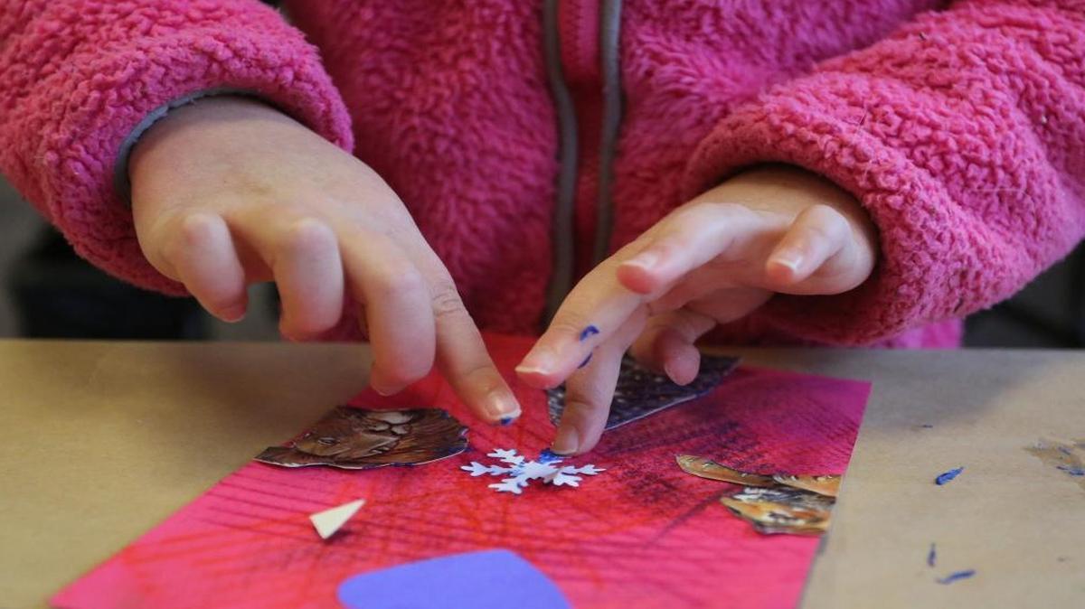 Ke’ala Stauber, then 7, uses glue on her fingers to affix a snowflake to a thank-you card in December 2012 at Bellingham Public Library.