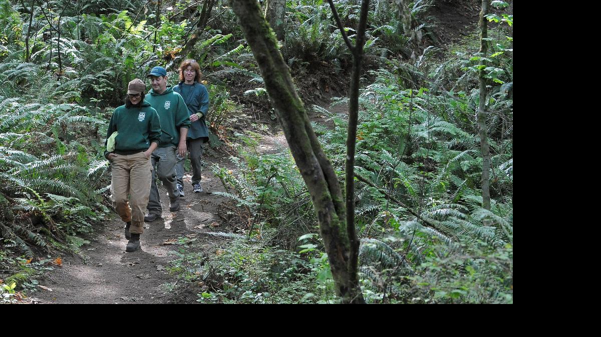 City of Bellingham employees Kirsten Miller, trail maintenance aid, left, Phil Evans, park trail technician, and Gina Giovanniello, Fairhaven Park manager, right, walk through Chuckanut Ridge looking for camps and trash on Aug. 23, 2012. Greenways money partially paid for the city’s acquisition of Chuckanut Ridge.
