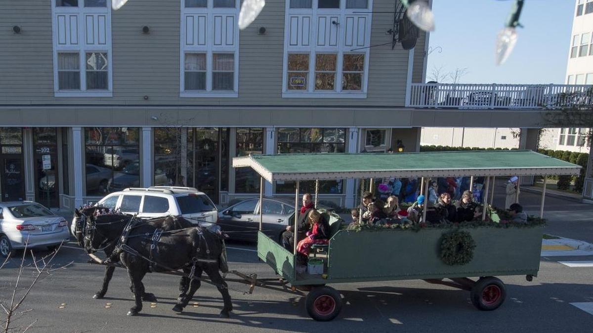 A horse-drawn wagon rolls down 10th Street outside Fairhaven Village Inn on Saturday, Nov. 28, 2015 in Bellingham, Wash.