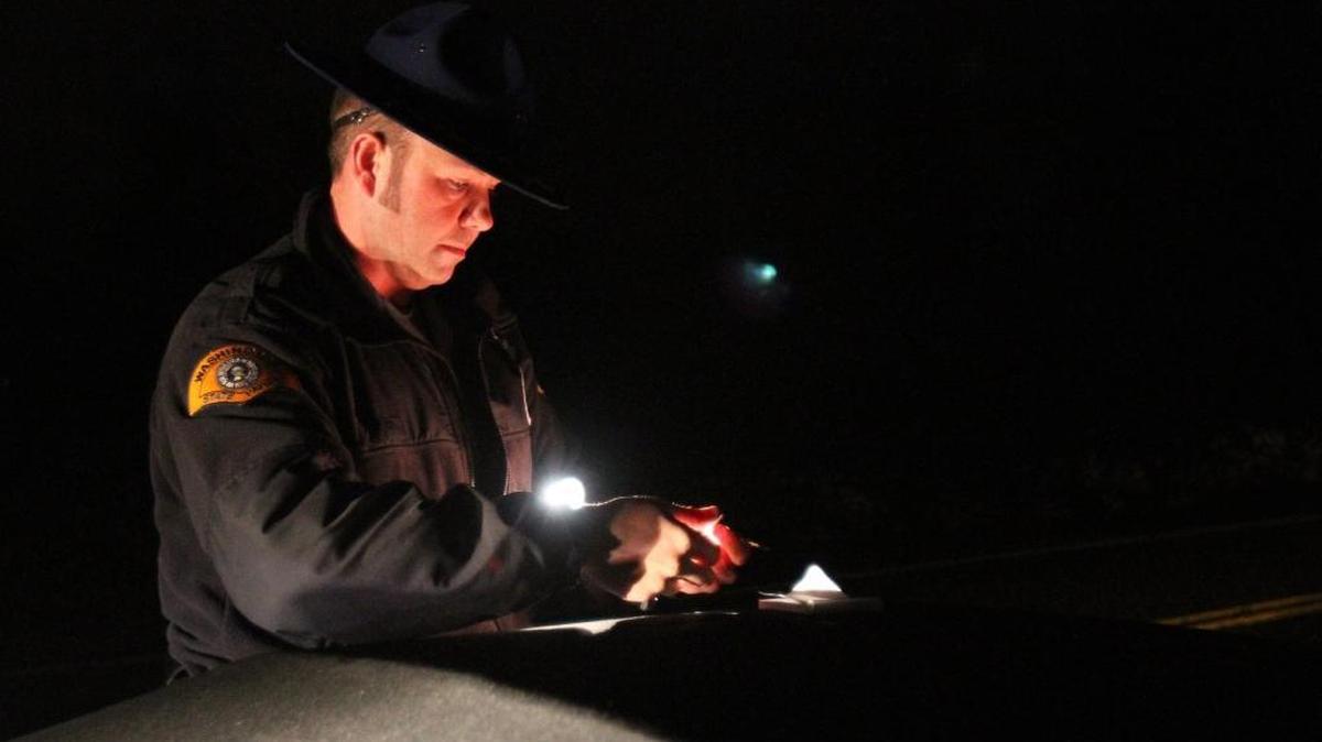 Washington State Patrol Trooper Guy Gill retrieves the personal belongings of a woman arrested on suspicion of driving under the influence in 2012. The state patrol, Whatcom County Sheriff’s Office and Bellingham Police will have extra officers on foot and on the roads over the holiday weekend.