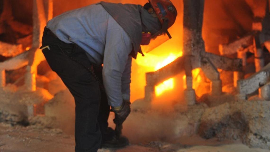Worker Kevin Daniels uses an alder stick to burp gas bubbles on a smelter pot on potline B at the Alcoa Intalco aluminum smelter west of Ferndale on Feb. 15, 2011. Alcoa is idling the smelter by early 2016 because of a glut of aluminum in the global market.