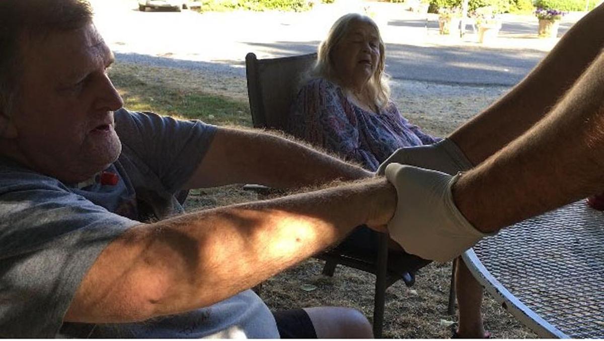 Bellingham Fire Capt. Jeff Brubaker checks client Robert Brazzel’s grip strength during a recent home visit. Brazzel’s wife Lindy Brazzel watches in the background.