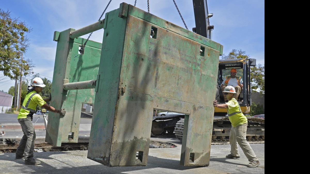 
Faber Construction workers Niceto Canete, left, and Matthew Romero guide a manhole box being lifted by an excavator operated by Heath Opel as the crew finished replacing a manhole on East Holly Street in Bellingham, Monday, June 15, 2015. The manhole replacement is one of several summer construction projects underway in Bellingham.
