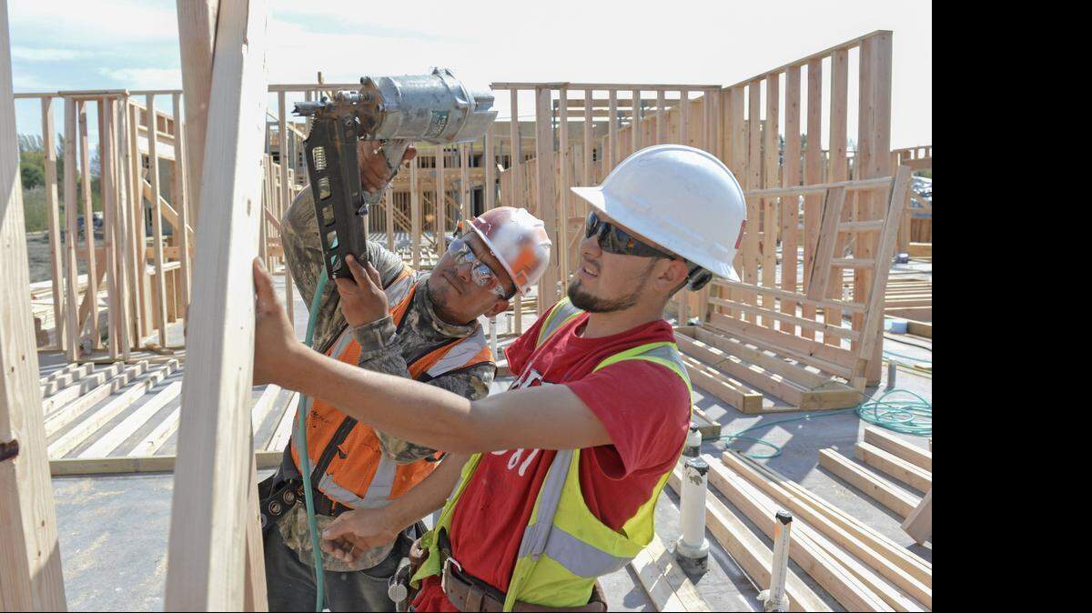 Hired Guns construction framers Juan Jose, left, and Joel Lara Cabrera put up a wall at the Affinity at Bellingham apartment complex under construction off Telegraph Road in Bellingham Tuesday, April 21, 2015. The 55-and-older complex is expected to be finished next March. It’s part of a boom in construction jobs in Whatcom County. 
