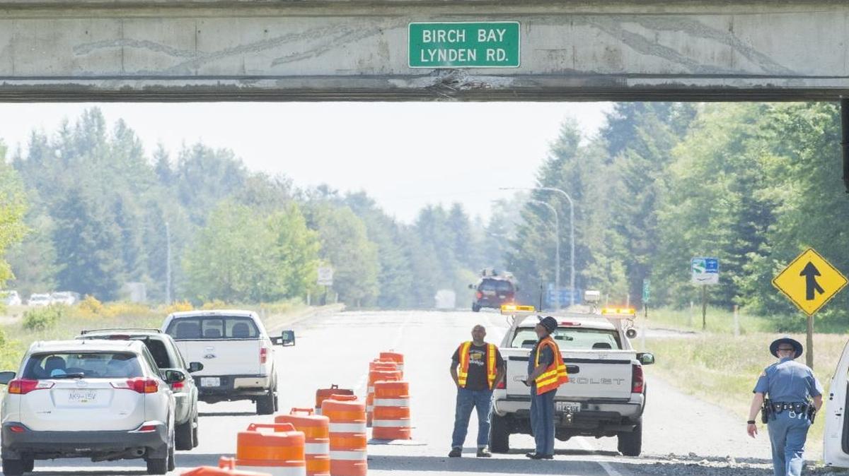 Washington Department of Transportation and Washington State Patrol employees assess damage to the Birch Bay-Lynden Road overpass on the southbound side of I-5 on May 21, 2015. The overpass was damaged by an excavator being hauled on a flatbed truck.