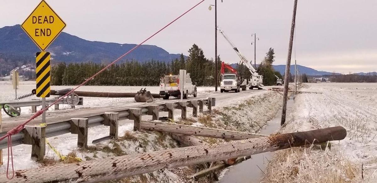 Crews put up new utility poles along Garrison Road near Sumas, Tuesday, Jan. 2, 2018.