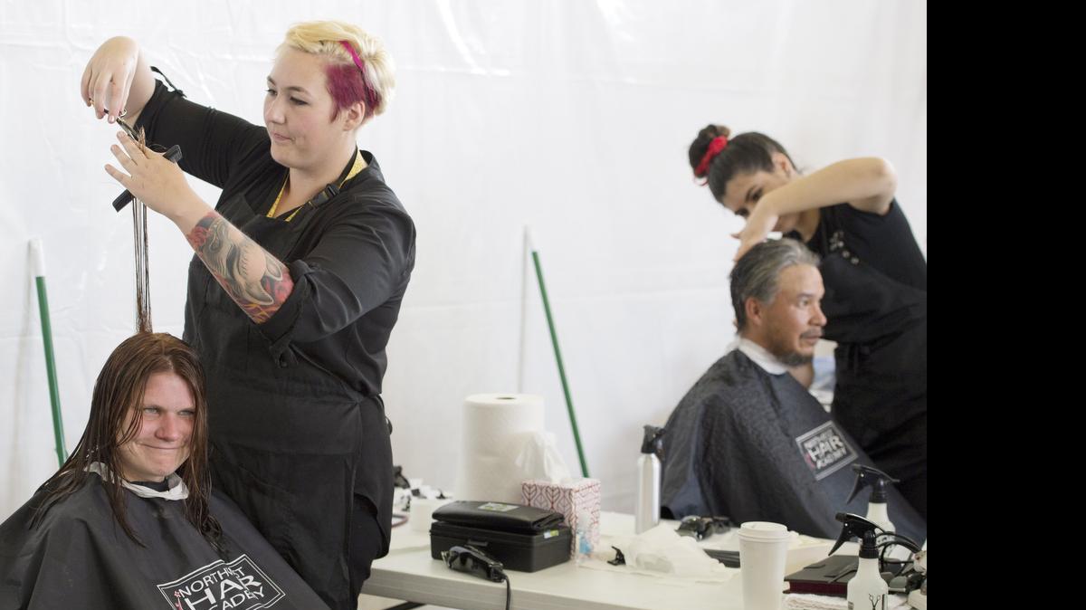 
Melanie Ficken cuts Tina VanDerwoude's hair at during the sixth annual Project Homeless Connect Friday, July 25, 2014, at Bellingham High School. This year’s event is Friday, July 24, at the high school.
