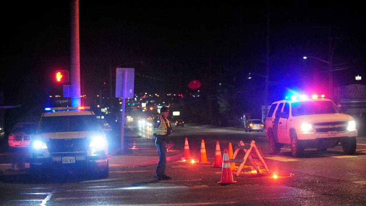 A Washington State Trooper directs traffic around a roadblock near Skagit Valley College in Mount Vernon, Wash., Thursday, Dec. 15, 2016. A Mount Vernon Police officer was shot and critically wounded by a suspect who was then barricaded in a Mount Vernon residence, authorities said.
