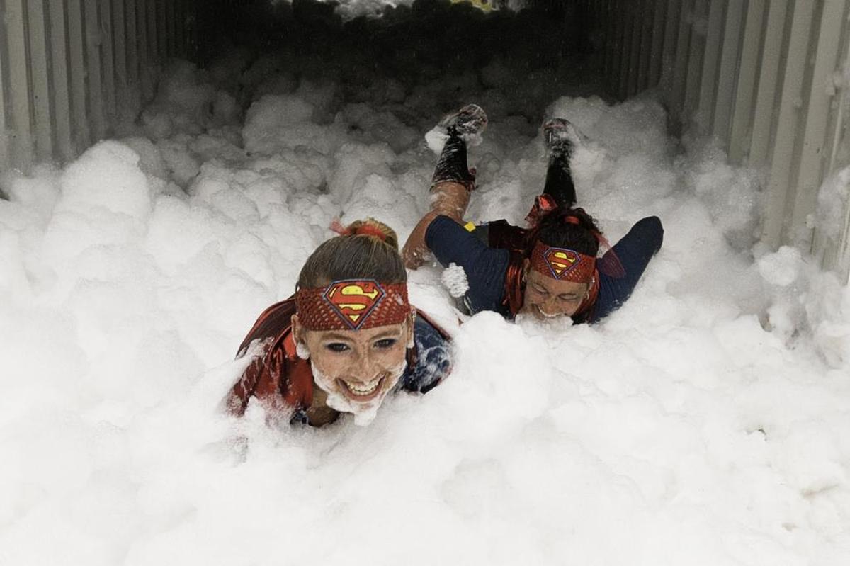 Lexi Warnke, left, and her mother Jessca Warnke of Mt. Vernon, slide through the Suds Box during the 3rd annual Mud to Suds race on Saturday morning August 16, 2014, at Hovander Park in Ferndale, Wash. This year’s races begin at 9 a.m. Saturday, Aug. 29, at the park.