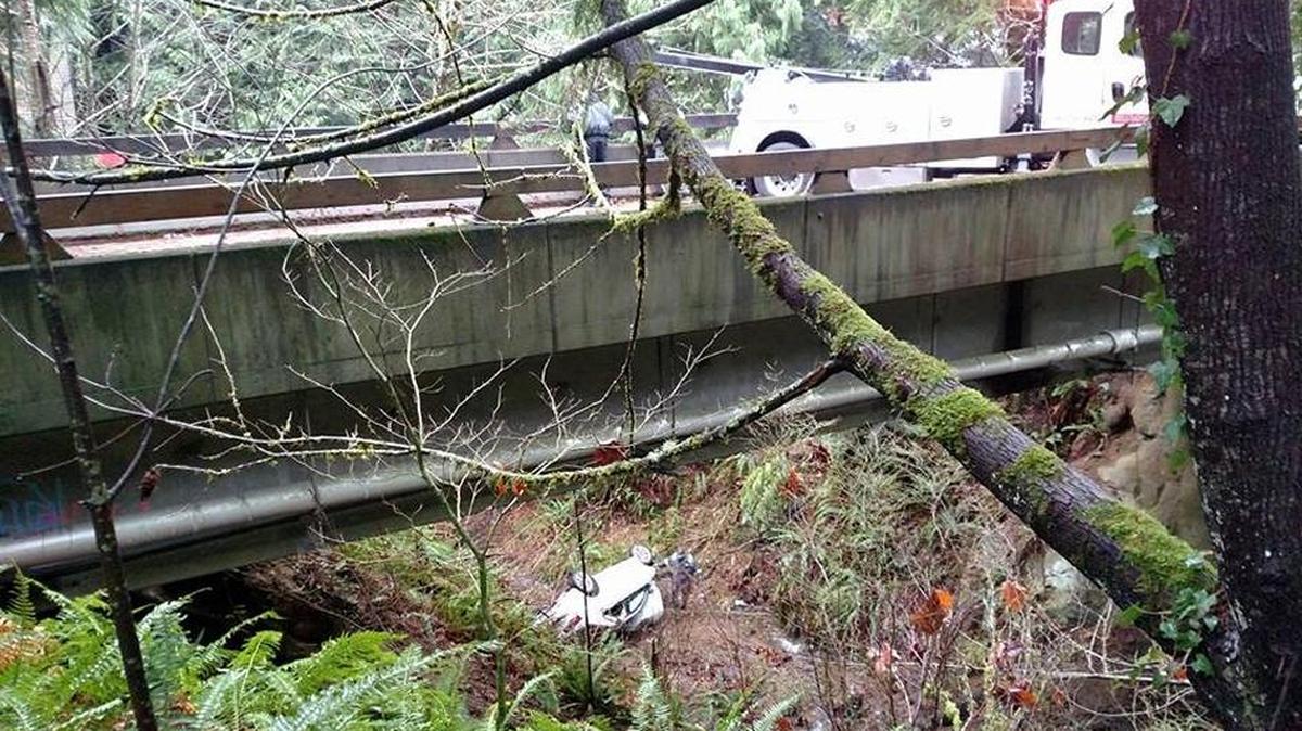 A wreck prepares to lift a car that plunged into a ravine below a bridge on Sudden valley Drive on Sunday morning, December 3.