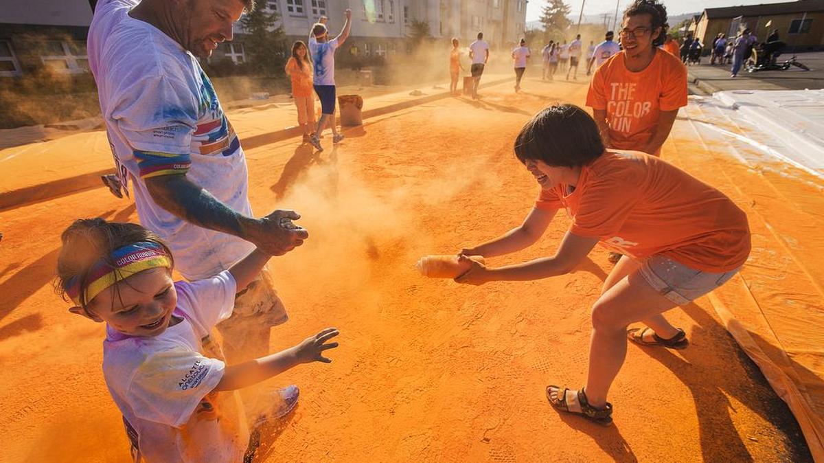 
Participants get sprayed by volunteers Mayu Takahashi and Jeff Bermudes, both from Bellingham, as they run through colored powders during the debut running of The Color Run 5K through Bellingham, Wash., on Sunday morning Aug. 16, 2015. The Color Run representative Kaitlin Syndergaard said over 5200 runners were registered for what is known as the Happiest 5K. She added that The Color Run partnered with the Whatcom Family YMCA to help raise funds for the organization.
