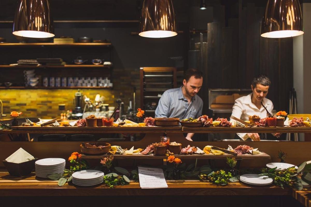 James Reynolds and Ciao Thyme co-owner Jessica Gillis prepare tapas for a Spanish-themed wedding in the Ciao Thyme Commons. The event room was completed about a year ago, but the company is planning to add more events to expand its use.