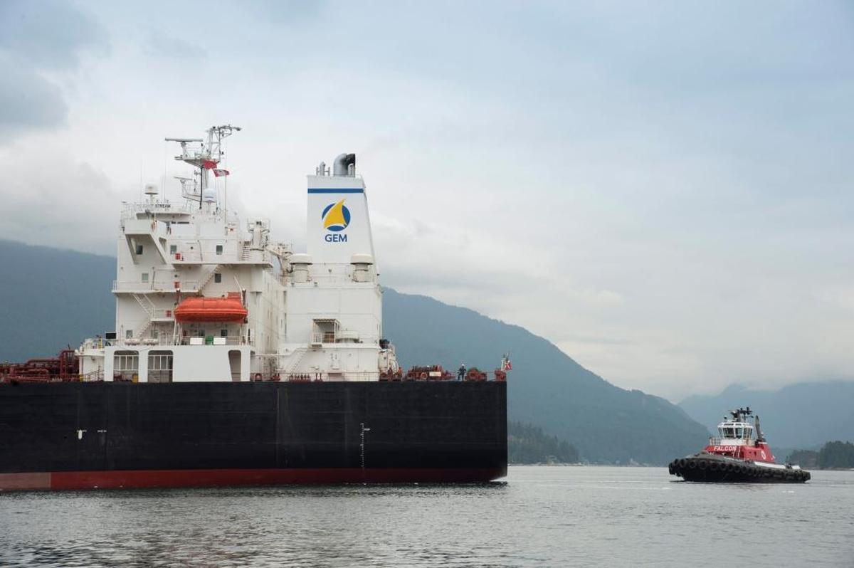A tug boat helps guide a tanker away from the docks at the Kinder Morgan Trans Mountain Expansion Project in Burnaby, British Columbia on June 4, 2015. Two Northwest Indian tribes are suing the U.S. Coast Guard, saying the agency has failed to protect endangered orcas from the risk of oil spills associated with tanker traffic in the region.