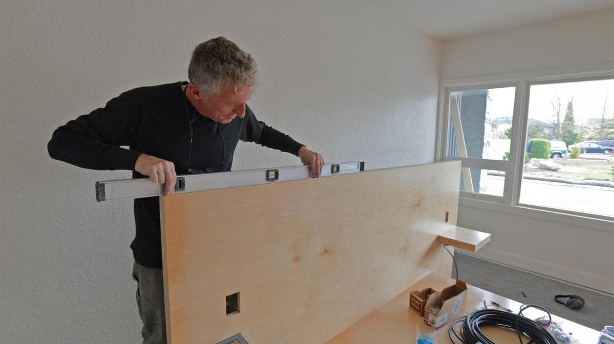 Troy Kirk of Clearstory Investments works on a custom bed frame in one of the rooms at the new Heliotrope Hotel on Elm Street in Bellingham, April 24, 2017. New owners will have an open house of the former Lions Inn Motel on May 13.