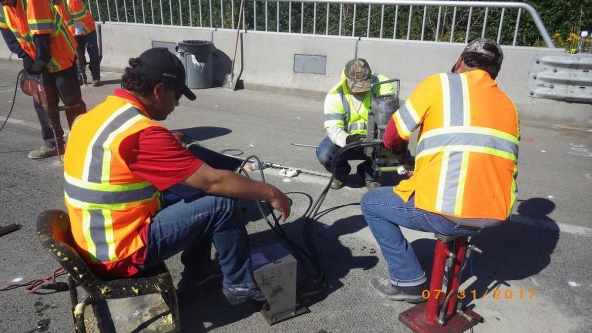 A road crew working for the Washington State Department of Transportation works to level a concrete bridge deck on Guide Meridian just south of Lynden, Washington on Monday, July 31, 2017. This week’s record-setting hot weather poses a risk to people who spend their days working outdoors.