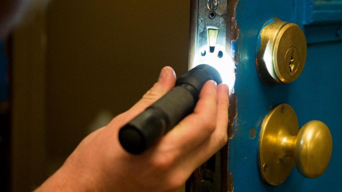 A Whatcom County maintenance services employee inspects a lock on Wednesday, July 8, at Whatcom County Jail in Bellingham, Wash.