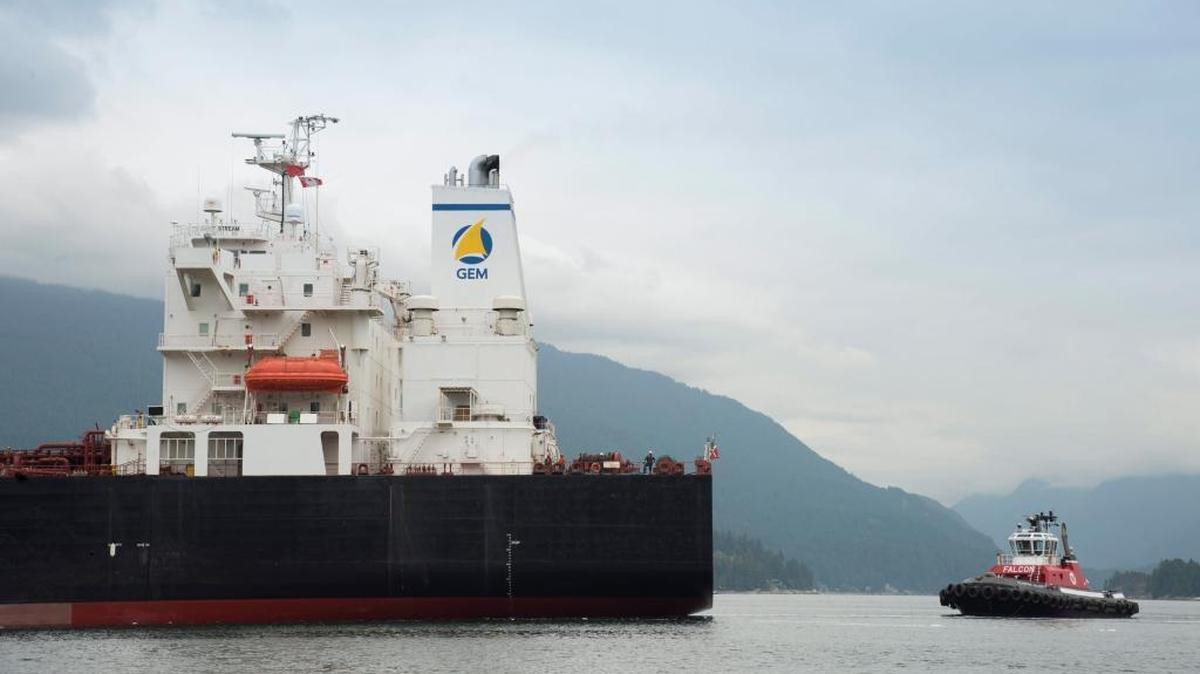 A tug boat helps guide a tanker away from the docks at the Kinder Morgan Trans Mountain Expansion Project in Burnaby, British Columbia, on June 4, 2015.