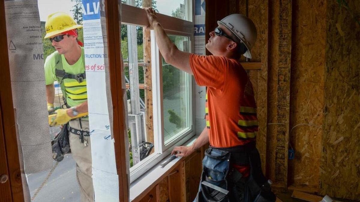 Ridgeway Construction workers Dylan Sielicki, left, and Kyle Conard install windows at the Bakerview Family Housing project under construction on East Bakerview Road in Bellingham, Tuesday, July 12, 2016. Whatcom County employs a higher percentage of people in construction, and pays higher than average, according to a new federal report.