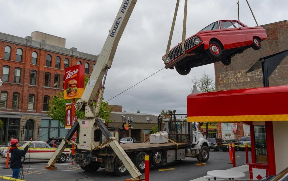 Workers from Pearson Construction and Bode’s Precast set a 1964 Ford Falcon on the roof of Zane Burger in Fairhaven on Wednesday, May 23, 2017.