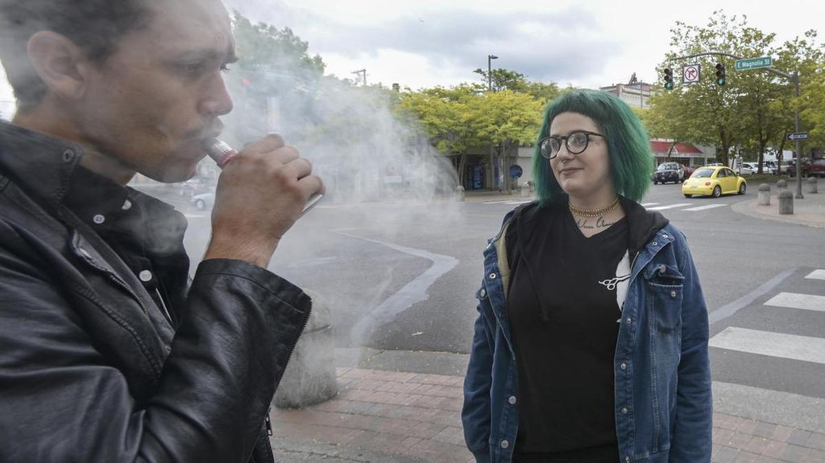 Cooper Lariviere, left, vapes while taking a break with his friend Bre Christy in downtown Bellingham on Tuesday, Aug. 9, 2016. Christy wasn’t too concerned about a proposal before the County Council to ban vaping in public places. She said she already makes sure she doesn’t vape around people who could be bothered by it.