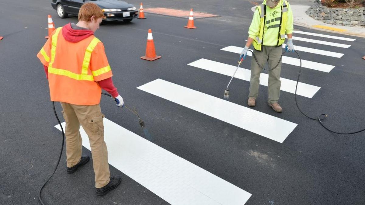 Tyler Kamps, left, and his father Darrin Kamps of Kamps Painting Co. install crosswalk boxes at Ellis and Alabama streets in Bellingham on Wednesday Nov. 4, 2015.