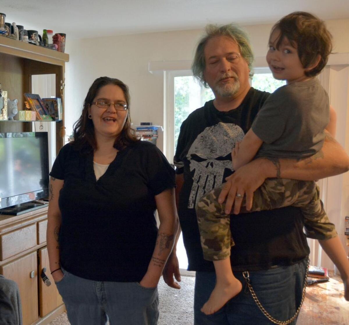Kasandra Boote, left, and Don and Jaxsen DeBeeld in the living room of their Sunset Drive apartment.