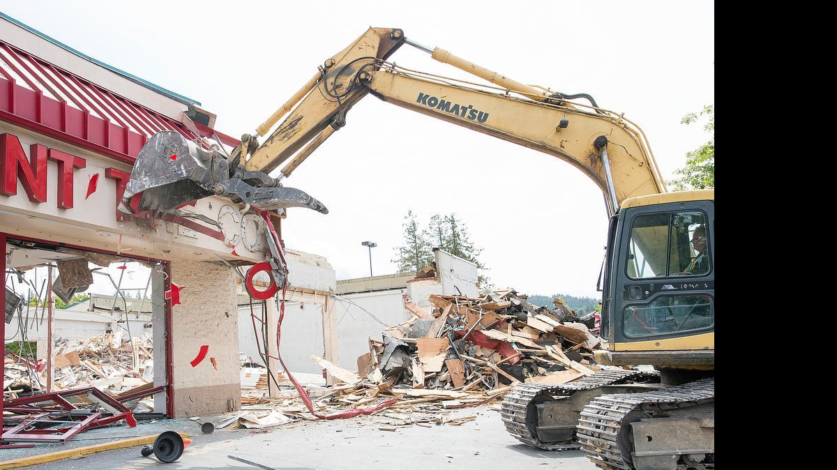 
Utility Pipeline Contractors employee Ross Poe uses an excavator to demolish the old Discount Tire Co. location on Tuesday, July 21, in Bellingham. The new Discount Tire shop is by the garden department of the Lakeway Fred Meyer.
