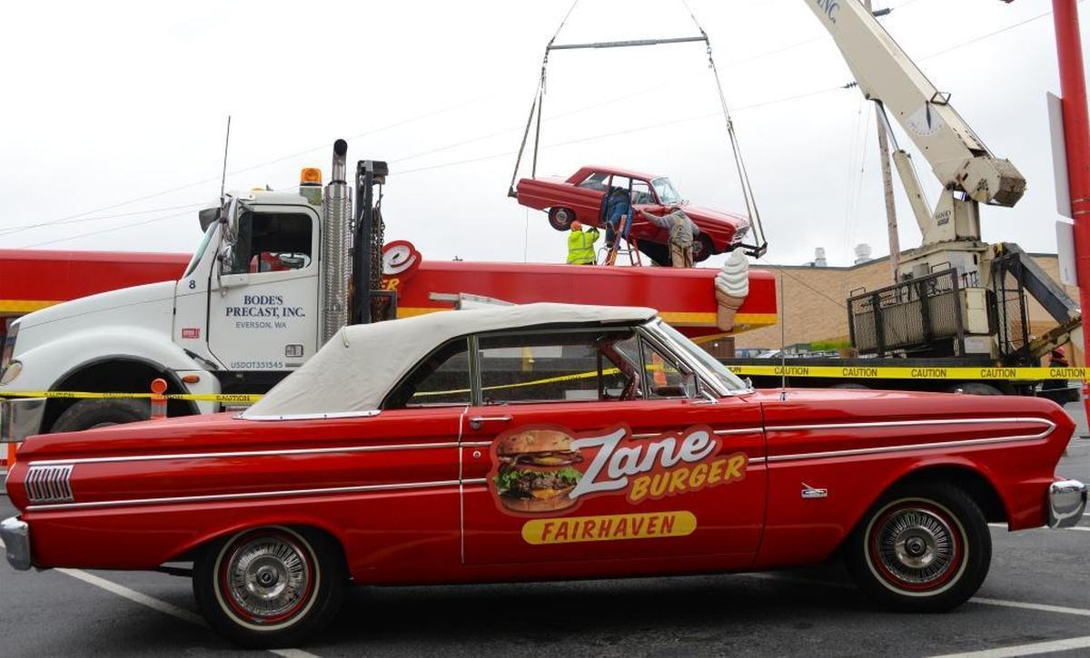 Workers from Pearson Construction and Bode’s Precast set a 1964 Ford Falcon on the roof of Zane Burger in Fairhaven on Wednesday, May 23, 2017.