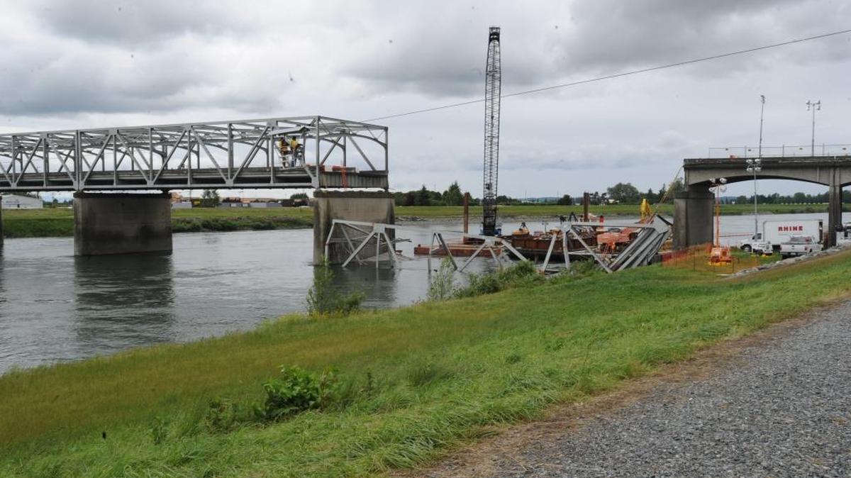 Workers inspect the damaged I-5 Skagit River bridge in 2013. The total cost of repairing the bridge, including installing temporary and permanent bridge spans, was about $19.8 million, according to the Department of Transportation.