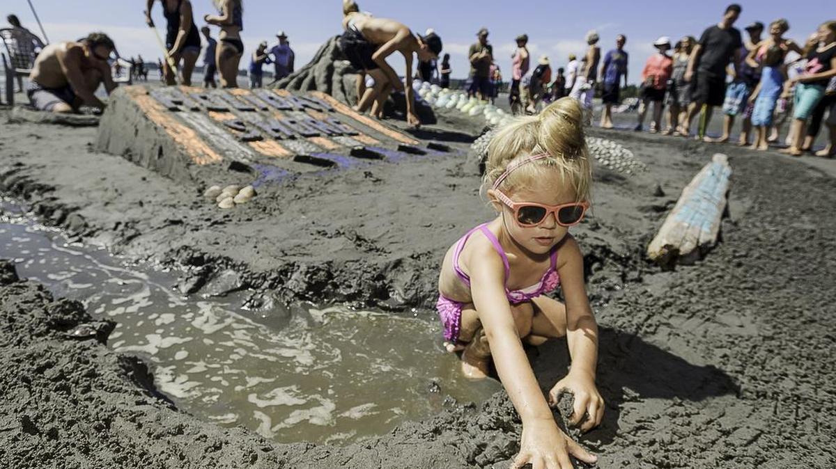 
Macy Tjoelker, 3, plays in the mud as her mother, Malorie Tjoelker of Lynden, and others work on a sandsculpture during the second day of the 32nd annual Birch Bay Sandsculpture Competition along the beach in Birch Bay, Wash., on July 19, 2015.
