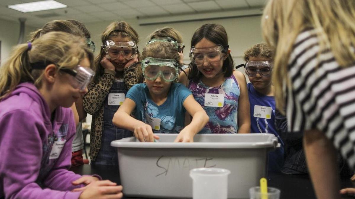 Fourth- and fifth-graders study expanding gases during a chemical reaction experiment at the Kids Night Out @ Western event in 2015.