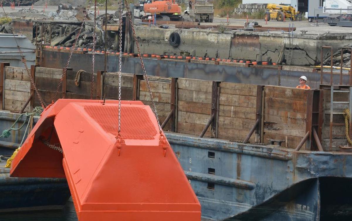 A worker stands near dredging equipment stationed in the middle of Whatcom Waterway on Wednesday, Aug. 12. Crews will clean up historic contamination in the downtown Bellingham channel this year.