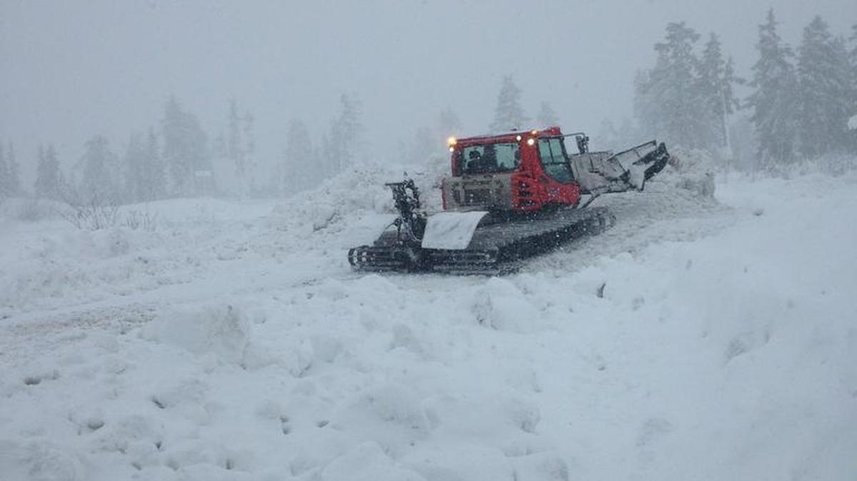 A tracked vehicle moves through deep snow as heavy snow falls near where searchers are looking for two snowboarders who have been missing since Sunday. They left their car at the Heather Meadows parking lot.