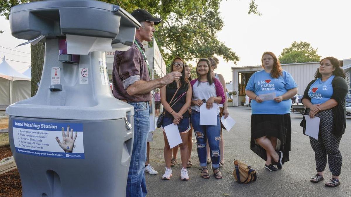 Whatcom County Health Department Environmental Health Supervisor Tom Kunnesh, left, briefs volunteers and hand -washing ambassadors on how to promote hand-washing at the Northwest Washington Fair in August 2015. The fair doubled its hand-washing stations to 24 after an E. coli outbreak at its dairy barn in April.