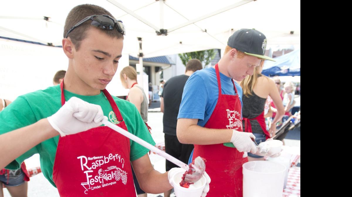
Alex Crabtree, left, and Tore Olson, right, prepare raspberry sundaes at the Northwest Raspberry Festival on July 18, 2014, in downtown Lynden. Despite an early harvest this year, there will be plenty of raspberries for the festival that runs Friday and Saturday, July 17 and 18.
