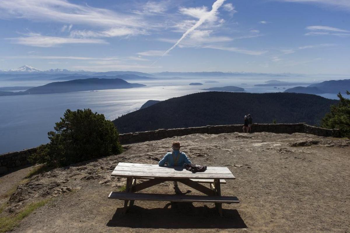 A visitor sits on top of Mount Constitution, part of Moran State Park and the highest point of the San Juan Islands.