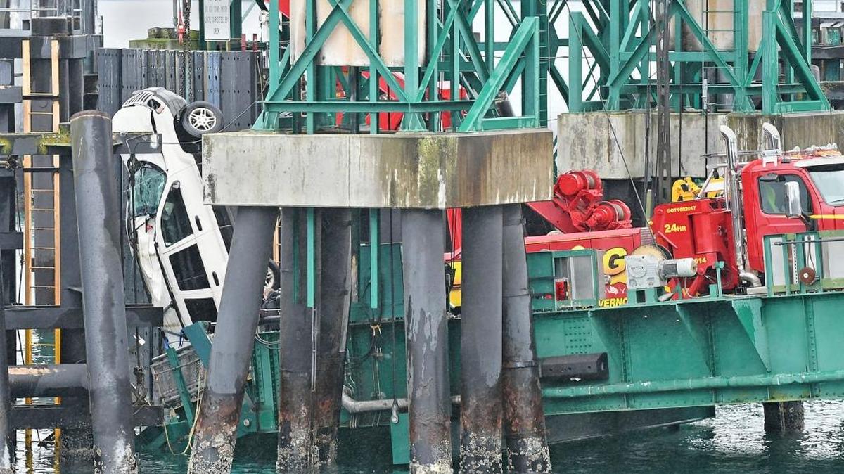 A tow truck lifts a white Jeep Cherokee vehicle out of the water at the Washington State Ferries terminal, Thursday, Jan. 25, 2018, in Anacortes, Wash. Authorities say Nicole K. Barney, 30, of Everett died after she drove her Jeep through a barrier and off a dock at the Washington State Ferries terminal at Anacortes.